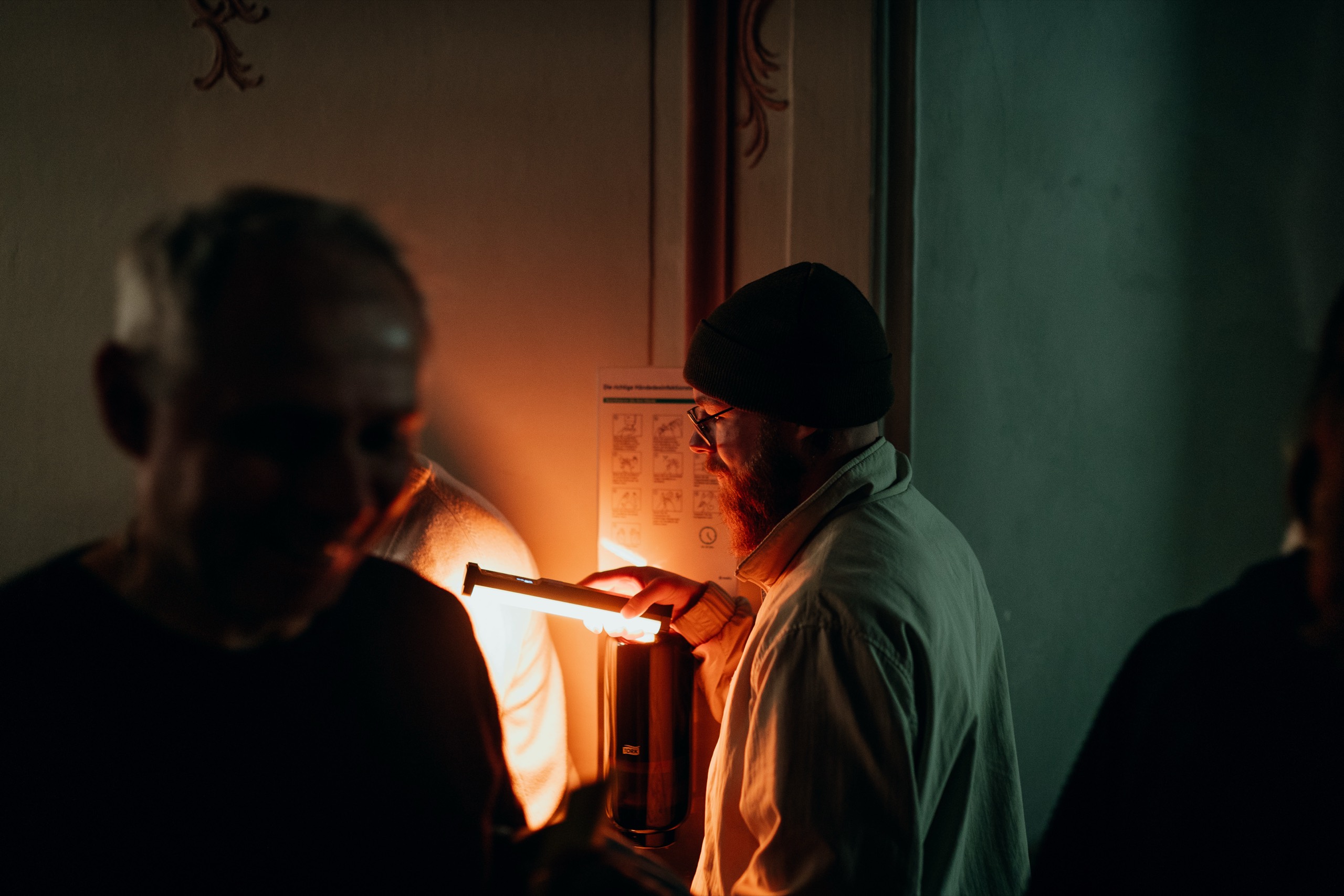 Teammitglied leuchtet eine Szene am Set mit einer warmen Lichtröhre aus