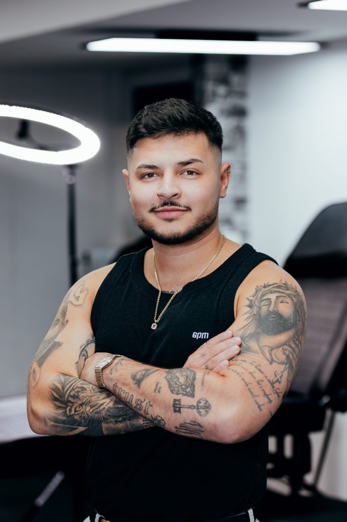 Porträt eines Tätowierers von Imperial Tattoo mit tätowierten Armen
