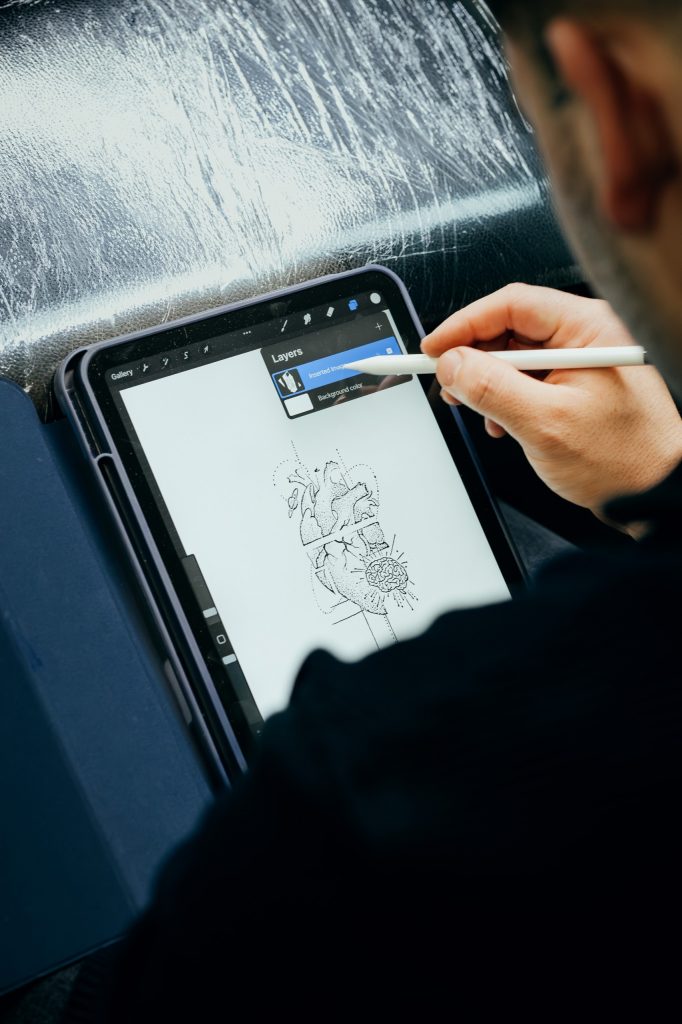 Tätowierer entwirft ein Tattoo-Motiv digital auf einem Tablet