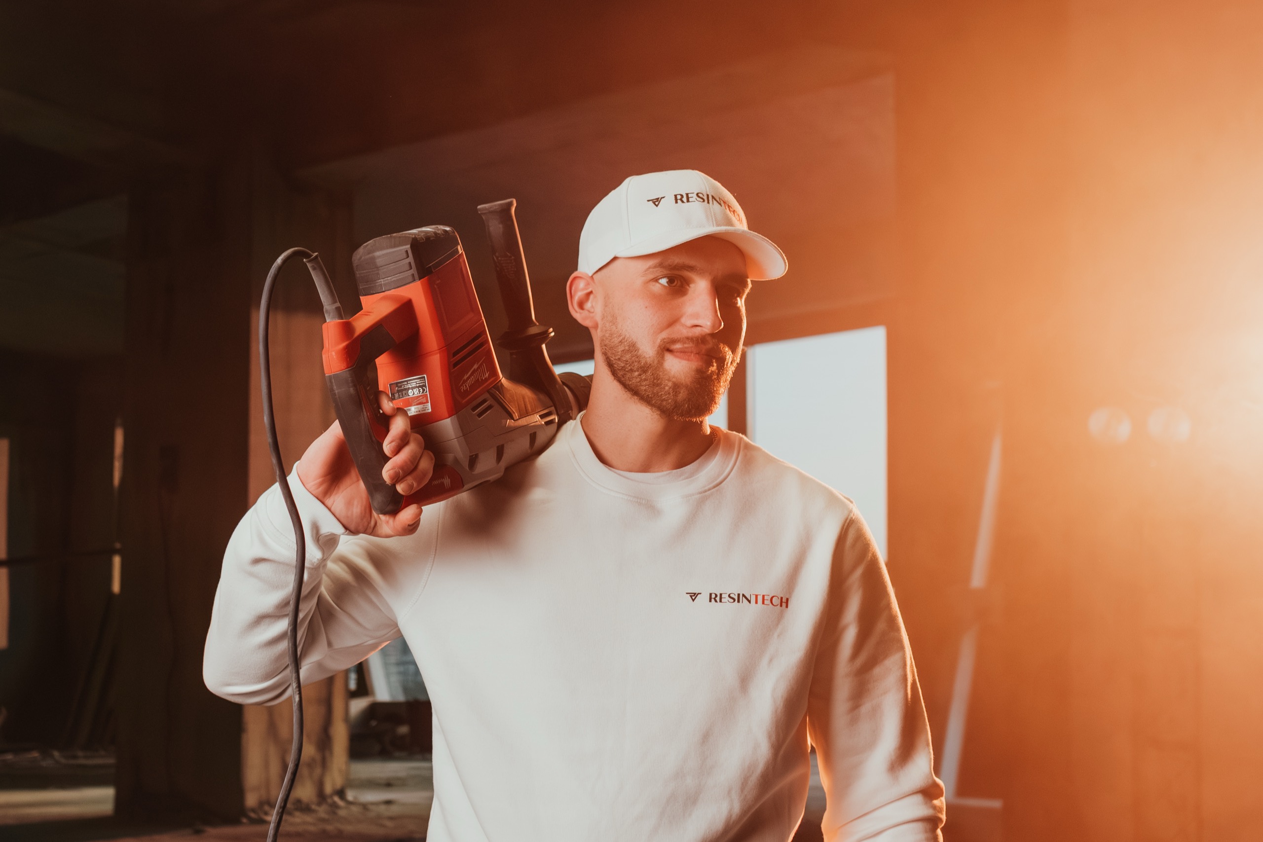 Mitarbeiter von Resintech mit Bohrhammer auf der Schulter