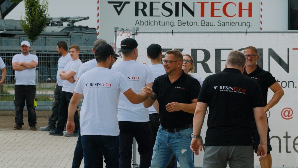 Resintech-Team vor dem Firmenwagen mit Logo und Leistungsübersicht